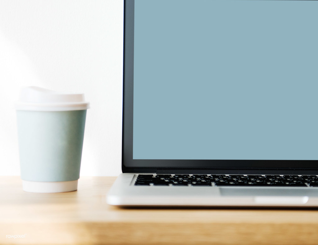 Laptop e caffe su scrivania in legno