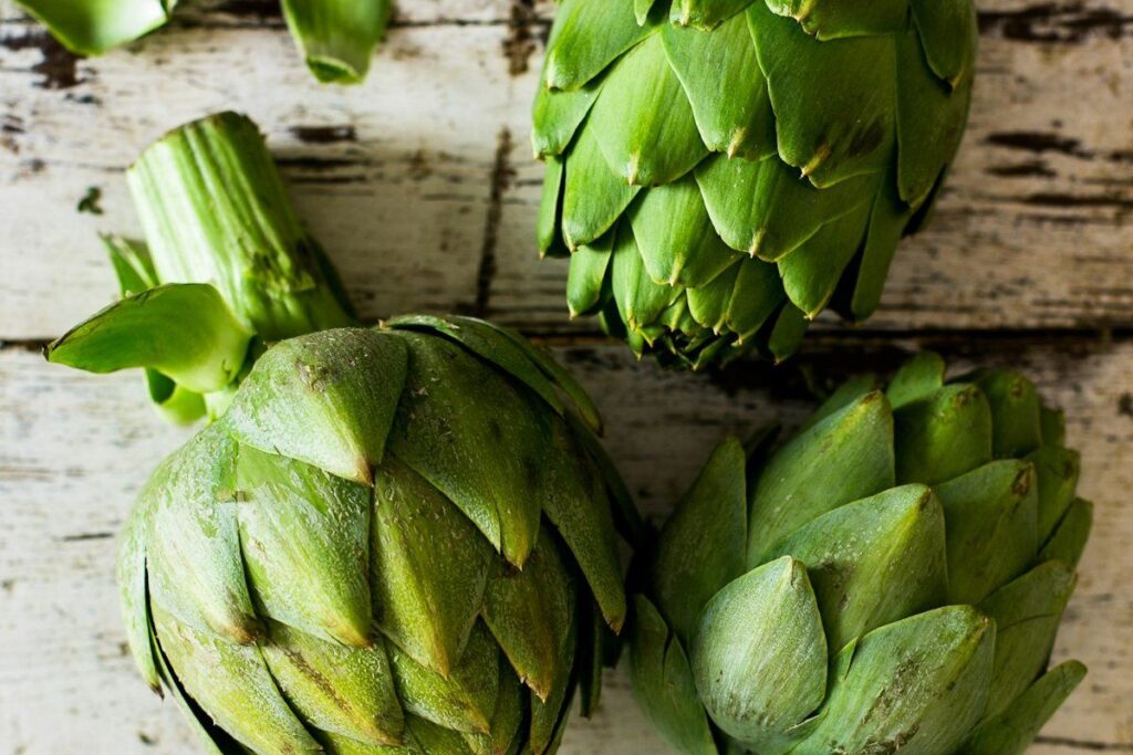 Carciofi freschi su un tavolo di legno chiaro