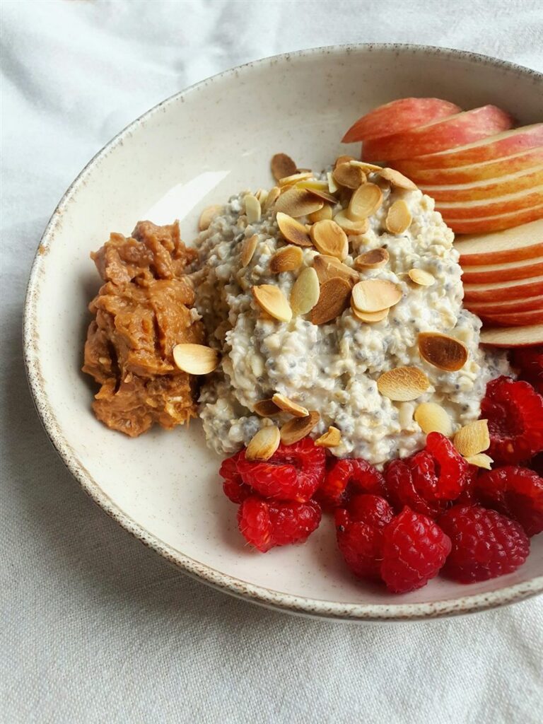 Ciotola di porridge con lamponi, mele e mandorle